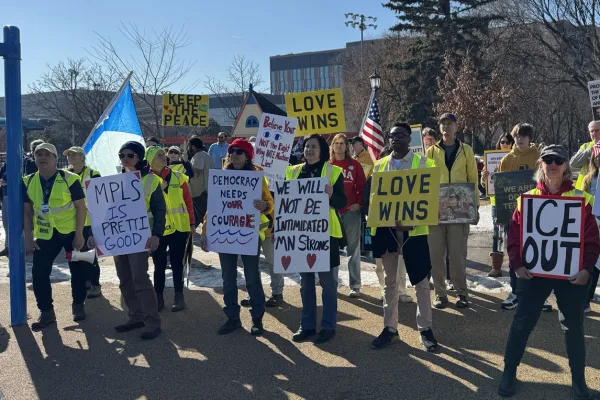 Minnesotans holding protest signs at an event in winter 2026.