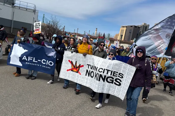 Photo of a group of people holding banners at a protest. One banner is the Minnesota AFL-CIO's logo, the other says "TWIN CITIES NO KINGS"